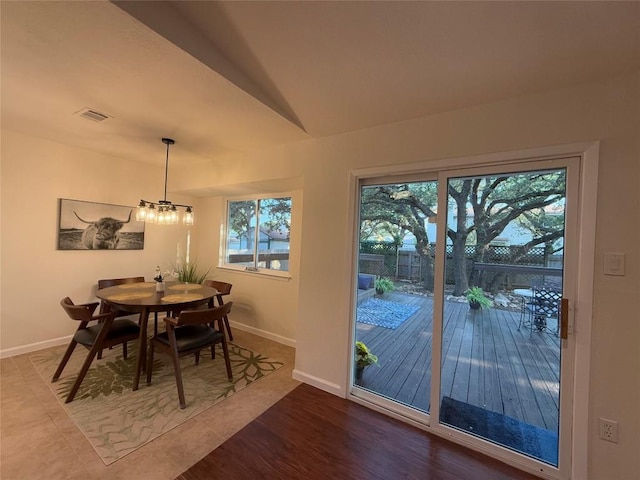 12225 Mosley Ln, Austin, TX 78727 - dining room featuring baseboards, healthy amount of natural light, wood finished floors, and vaulted ceiling