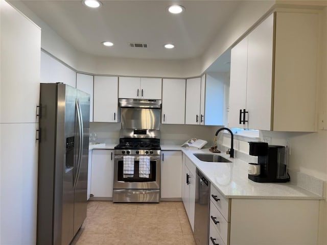 12225 Mosley Ln, Austin, TX 78727 - kitchen with stainless steel appliances, a sink, recessed lighting, light tile patterned flooring, and white cabinetry