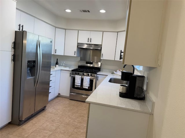 12225 Mosley Ln, Austin, TX 78727 - kitchen with appliances with stainless steel finishes, under cabinet range hood, white cabinetry, light stone countertops, and recessed lighting