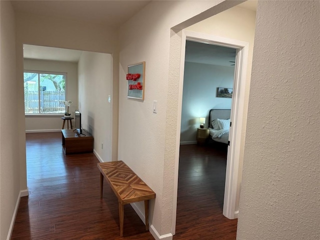 12225 Mosley Ln, Austin, TX 78727 - hall with dark wood-style floors, a textured wall, and baseboards