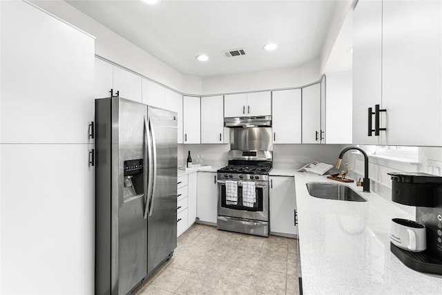 12225 Mosley Ln, Austin, TX 78727 - kitchen featuring stainless steel appliances, under cabinet range hood, white cabinets, light stone counters, and recessed lighting