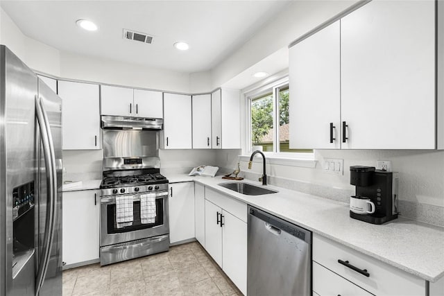 12225 Mosley Ln, Austin, TX 78727 - kitchen with appliances with stainless steel finishes, under cabinet range hood, white cabinets, recessed lighting, and light tile patterned floors