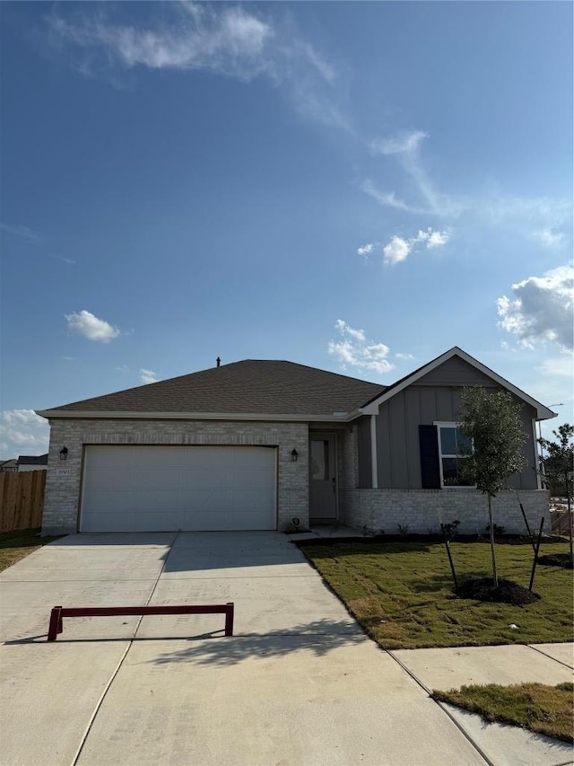 20503 Ed Townes Ter, Manor, TX 78653 - ranch-style house featuring concrete driveway, an attached garage, brick siding, and board and batten siding