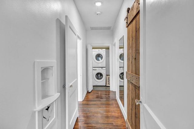 803 Josephine St, Austin, TX 78704 - laundry area with estacked washer and dryer, dark wood-type flooring, and a barn door