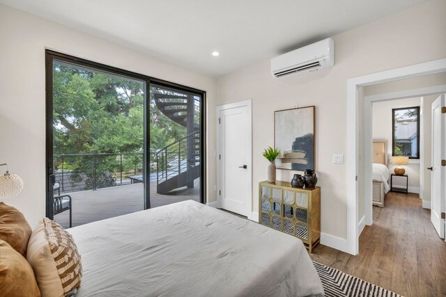 803 Josephine St, Austin, TX 78704 - bedroom with a wall mounted AC, access to exterior, wood finished floors, baseboards, and recessed lighting