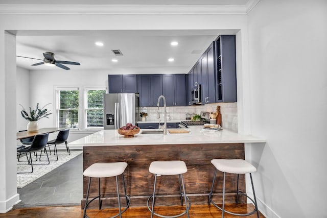 803 Josephine St, Austin, TX 78704 - kitchen with stainless steel appliances, a peninsula, a breakfast bar, light countertops, and recessed lighting