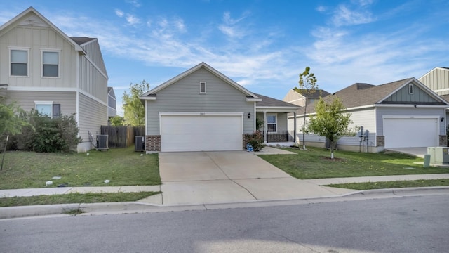 13013 Titanium St, Austin, TX 78754 - view of front of home with board and batten siding, cooling unit, a front lawn, and driveway
