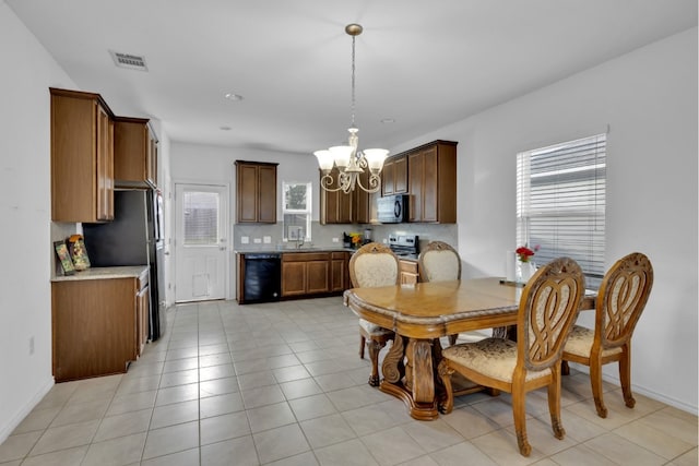 13013 Titanium St, Austin, TX 78754 - dining area featuring a chandelier, plenty of natural light, light tile patterned floors, and baseboards