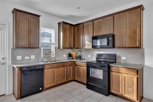 13013 Titanium St, Austin, TX 78754 - kitchen featuring black appliances, a sink, light stone counters, and decorative backsplash
