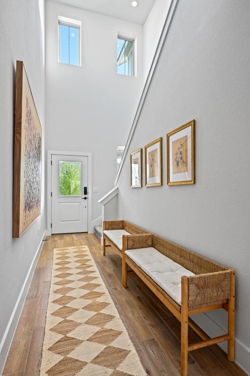 8513 Cottage Rose Dr, Austin, TX 78744 - entryway featuring light wood finished floors, stairway, a towering ceiling, baseboards, and recessed lighting