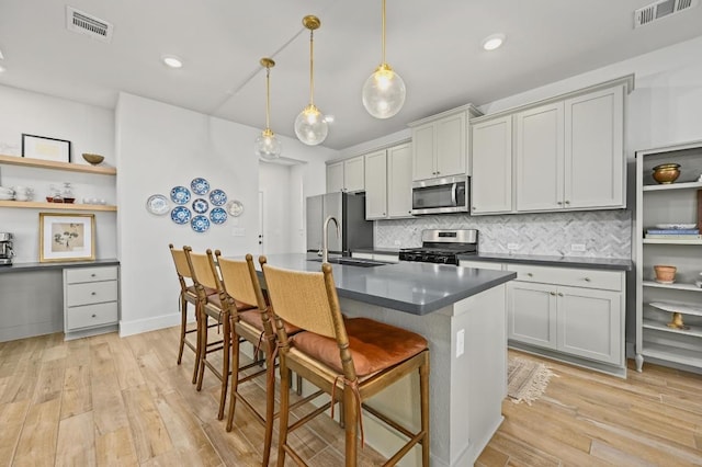 8513 Cottage Rose Dr, Austin, TX 78744 - kitchen featuring appliances with stainless steel finishes, dark countertops, a kitchen bar, a sink, and decorative backsplash