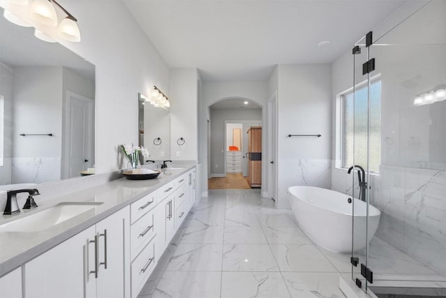 413 Mercer Falls Rd, Lakeway, TX 78738 - bathroom with double vanity, marble finish floors, a soaking tub, and a shower stall