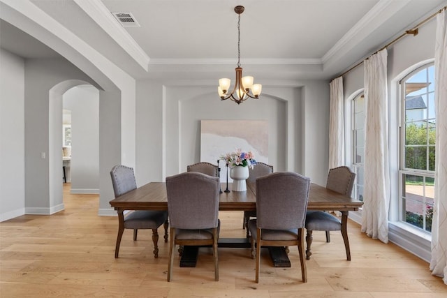 413 Mercer Falls Rd, Lakeway, TX 78738 - dining area featuring a chandelier, arched walkways, light wood finished floors, a raised ceiling, and ornamental molding