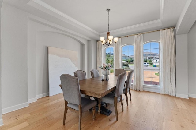 413 Mercer Falls Rd, Lakeway, TX 78738 - dining space with a tray ceiling, a chandelier, light wood-style floors, baseboards, and crown molding