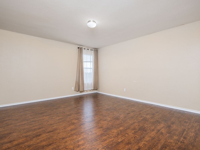 235 Herrera Trl, Hutto, TX 78634 - spare room featuring dark wood-style floors and baseboards