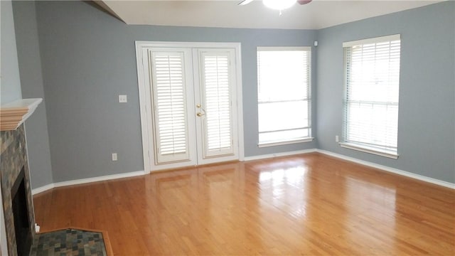 12828 Withers Way, Austin, TX 78727 - unfurnished living room with a fireplace, wood finished floors, a ceiling fan, and baseboards
