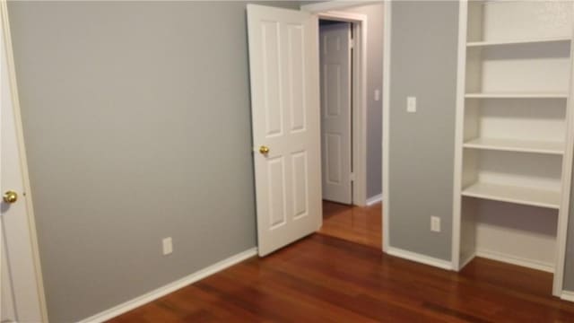 12828 Withers Way, Austin, TX 78727 - unfurnished bedroom with dark wood-style flooring and baseboards
