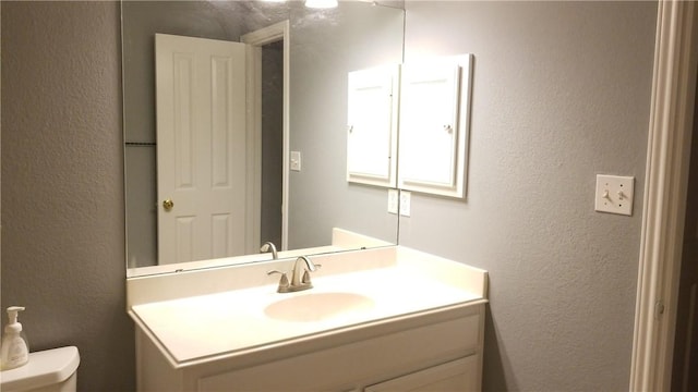 12828 Withers Way, Austin, TX 78727 - bathroom featuring vanity, toilet, and a textured wall