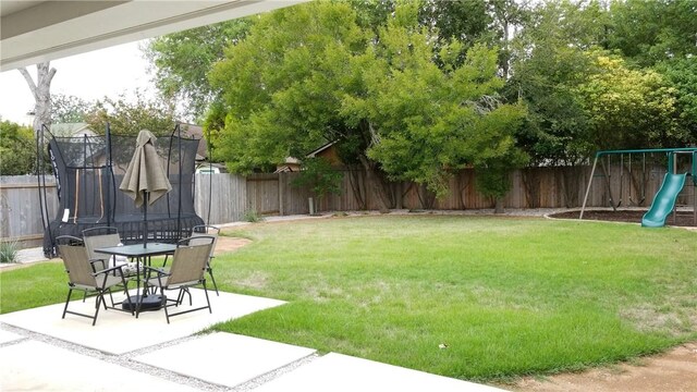 12828 Withers Way, Austin, TX 78727 - view of yard featuring a trampoline, a patio, a playground, and outdoor dining space