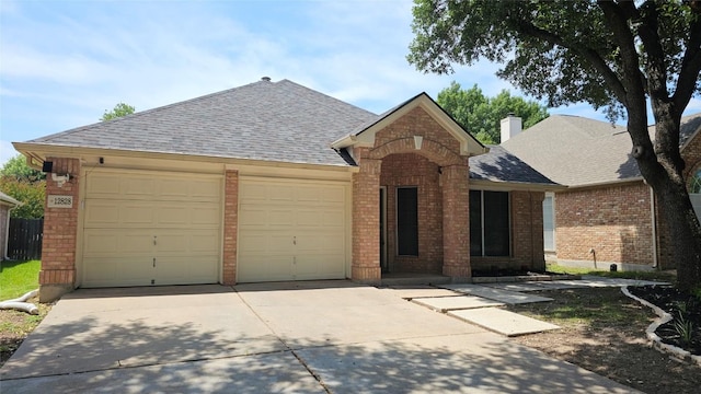 12828 Withers Way, Austin, TX 78727 - view of front of property with brick siding, an attached garage, and concrete driveway