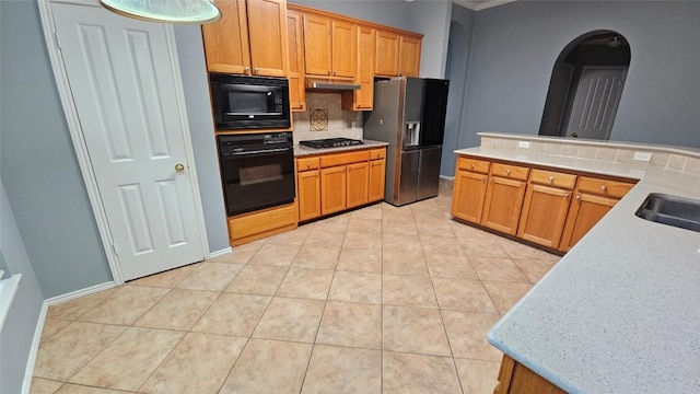 12828 Withers Way, Austin, TX 78727 - kitchen featuring black appliances, decorative backsplash, arched walkways, light tile patterned floors, and light countertops