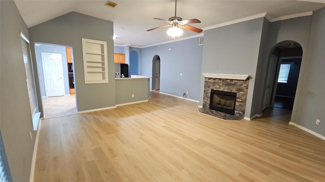 12828 Withers Way, Austin, TX 78727 - unfurnished living room featuring arched walkways, a ceiling fan, a fireplace, light wood-type flooring, and ornamental molding