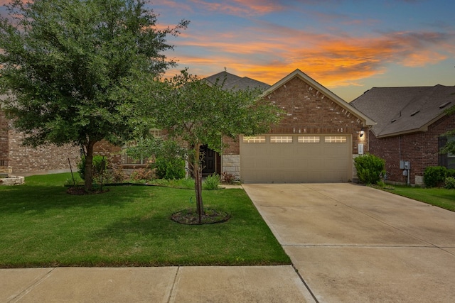 1916 Elaina Loop, Leander, TX 78641 - view of front of property with brick siding, an attached garage, concrete driveway, and a front yard