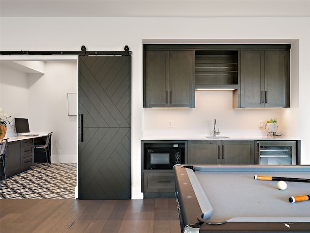 6037 Verandero Ct, Austin, TX 78738 - kitchen with a sink, light countertops, dark wood-type flooring, black microwave, and wine cooler