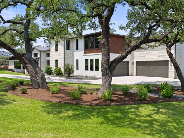6037 Verandero Ct, Austin, TX 78738 - contemporary home featuring concrete driveway, a front yard, stone siding, and a standing seam roof