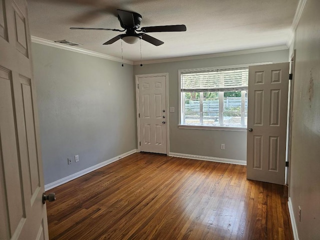 1407 Wilshire Blvd, Austin, TX 78722 - spare room featuring dark wood-type flooring, a ceiling fan, baseboards, and ornamental molding