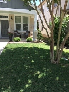 387 Mcgarity, Kyle, TX 78640 - doorway to property featuring a porch and a yard