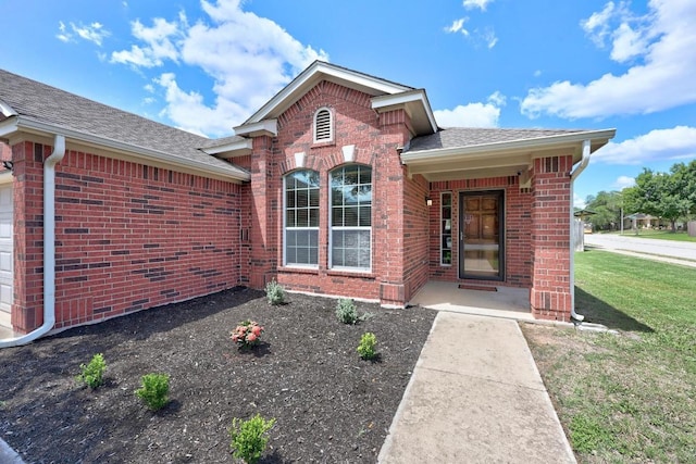 2801 Stirrup Cv, Leander, TX 78641 - property entrance featuring brick siding, roof with shingles, and a lawn