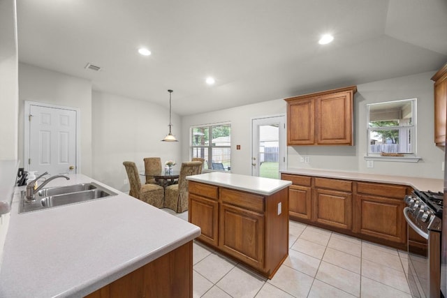2801 Stirrup Cv, Leander, TX 78641 - kitchen with stainless steel range with gas cooktop, a sink, brown cabinetry, light countertops, and recessed lighting