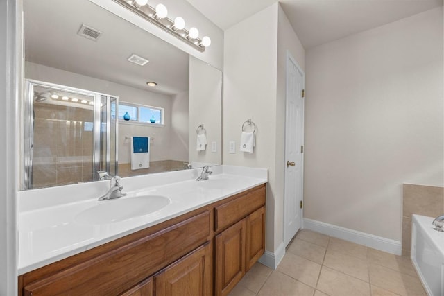 2801 Stirrup Cv, Leander, TX 78641 - bathroom with double vanity, a bath, tile patterned floors, baseboards, and an enclosed shower