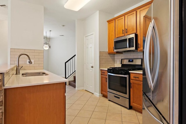 1900 Scofield Ridge Parkway Unit 1703, Austin, TX 78727 - kitchen with appliances with stainless steel finishes, a sink, backsplash, brown cabinets, and light tile patterned floors