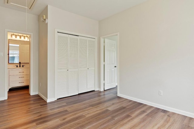 1900 Scofield Ridge Parkway Unit 1703, Austin, TX 78727 - unfurnished bedroom featuring attic access, wood finished floors, baseboards, a closet, and ensuite bath