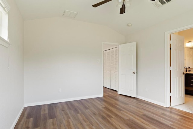1900 Scofield Ridge Parkway Unit 1703, Austin, TX 78727 - unfurnished bedroom featuring wood finished floors, lofted ceiling, baseboards, a closet, and ceiling fan