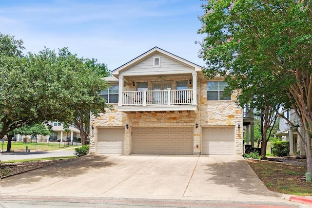 1900 Scofield Ridge Parkway Unit 1703, Austin, TX 78727 - view of property with stone siding, a garage, a balcony, and concrete driveway
