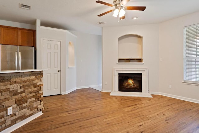 1900 Scofield Ridge Parkway Unit 1703, Austin, TX 78727 - unfurnished living room with ceiling fan, light wood-style floors, a glass covered fireplace, and baseboards