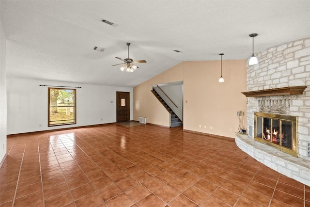 708 Post Oak Dr, Dripping Springs, TX 78620 - unfurnished living room with a ceiling fan, lofted ceiling, tile patterned floors, stairway, and a stone fireplace