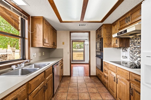 708 Post Oak Dr, Dripping Springs, TX 78620 - kitchen featuring black appliances, a sink, under cabinet range hood, light countertops, and a textured ceiling