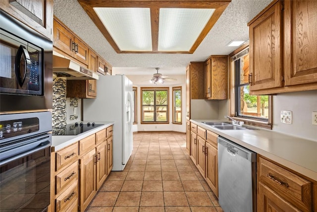 708 Post Oak Dr, Dripping Springs, TX 78620 - kitchen featuring stainless steel appliances, under cabinet range hood, light countertops, a sink, and brown cabinetry