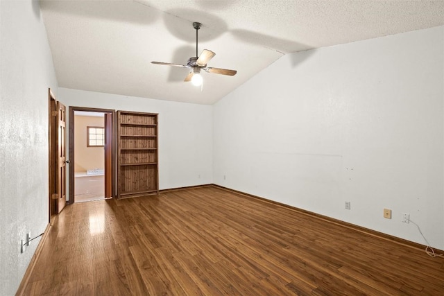 708 Post Oak Dr, Dripping Springs, TX 78620 - unfurnished bedroom featuring vaulted ceiling, wood finished floors, baseboards, a ceiling fan, and a textured ceiling