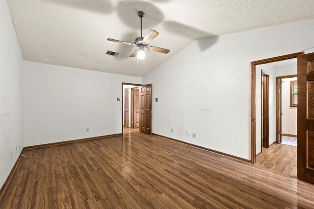 708 Post Oak Dr, Dripping Springs, TX 78620 - empty room with a ceiling fan, wood finished floors, lofted ceiling, baseboards, and a textured ceiling
