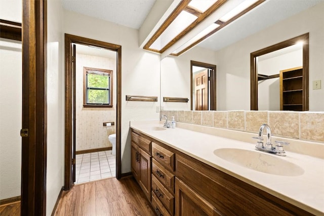 708 Post Oak Dr, Dripping Springs, TX 78620 - bathroom with toilet, double vanity, wood finished floors, and baseboards