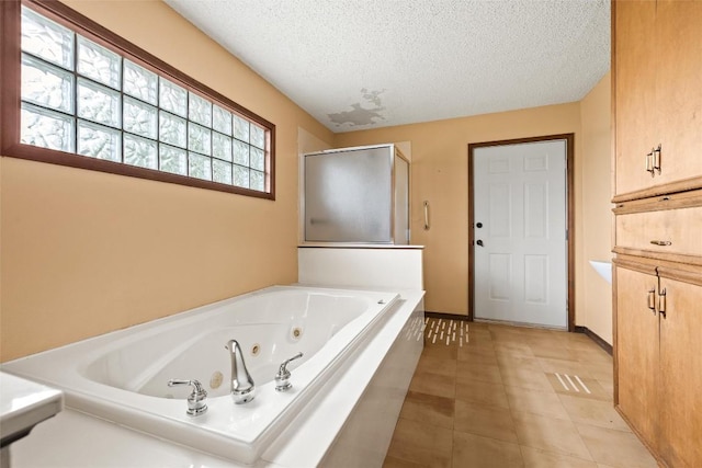 708 Post Oak Dr, Dripping Springs, TX 78620 - full bath featuring a textured ceiling, a shower stall, a jetted tub, tile patterned floors, and baseboards