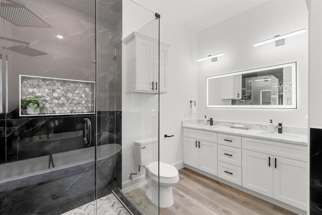 147 Puu Waa Waa Ln, Bastrop, TX 78602 - bathroom featuring double vanity, a stall shower, toilet, and wood finished floors