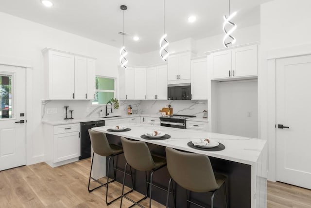 147 Puu Waa Waa Ln, Bastrop, TX 78602 - kitchen with dishwasher, stainless steel electric range, white cabinetry, backsplash, and light wood-style flooring