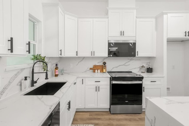 147 Puu Waa Waa Ln, Bastrop, TX 78602 - kitchen featuring electric stove, white cabinetry, backsplash, light wood-style flooring, and light stone countertops