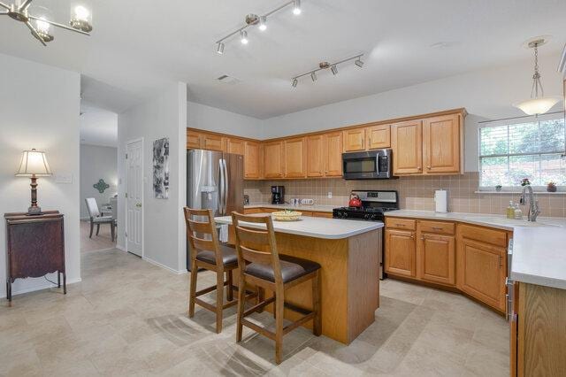 14800 Banbridge Trl, Austin, TX 78717 - kitchen with stainless steel appliances, a sink, light countertops, and tasteful backsplash